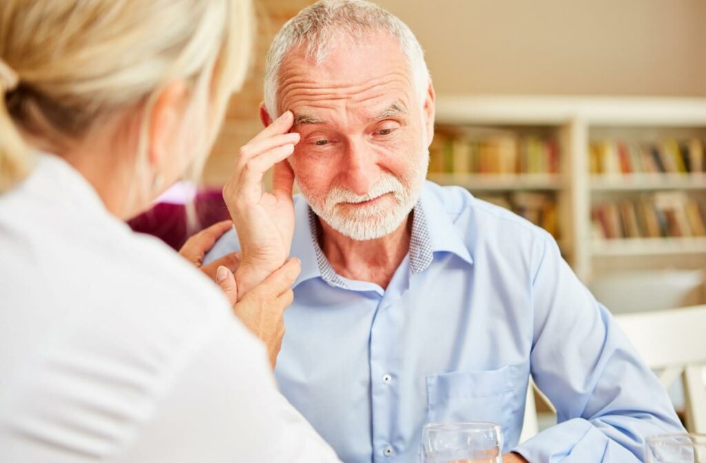 A doctor examining an older adult man who has signs of disorientation