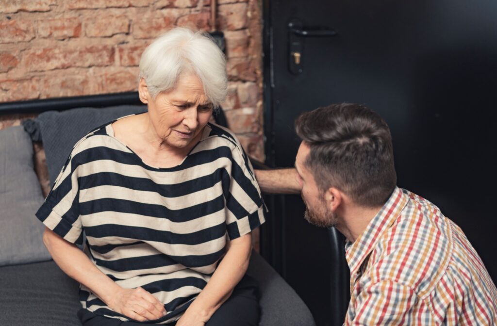 An adult child communicating with a parent with dementia.